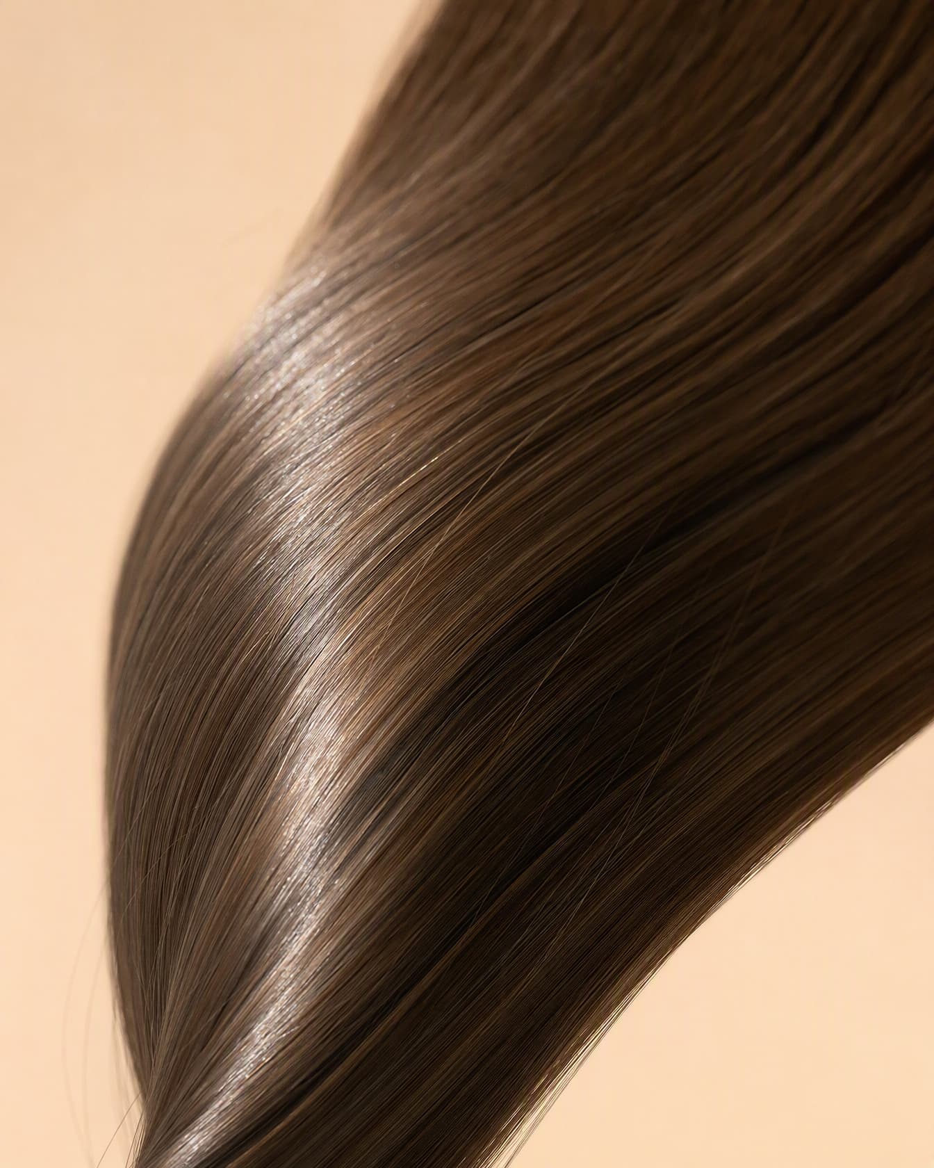 Macro of aligned hair cuticles with a glass-like shine on a nude backdrop